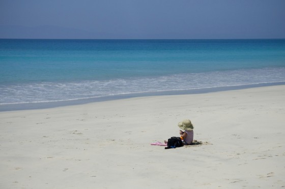 Child sitting on beach.